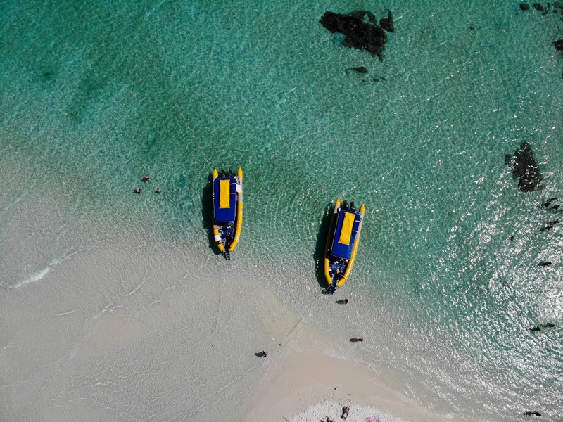 fotografía aérea de dos barcos de color amarillo en la costa en una de las playas cristalinas de las Islas WhitSundays